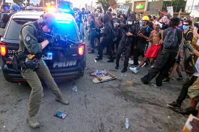 Police attempt to control protesters outside a Wendy's restaurant. AP