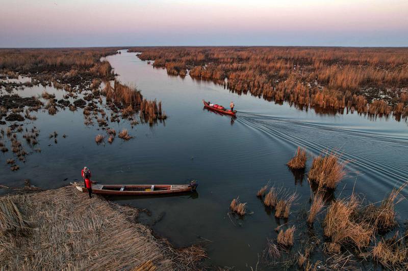 A man standing on a boat cruising in Iraq's southern marshes of Chibayish, in Dhi Qar province.  AFP