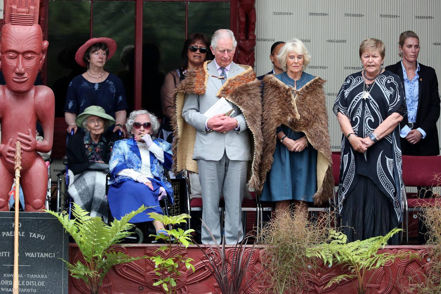 Britain's Prince Charles, center, and his wife Camila stand during a ceremony at Waitangi in New Zealand, Wednesday, Nov. 20, 2019. The couple visited  the historic Waitangi Treaty Grounds, where the nationâ€™s founding document was signed. It is the first visit there by a member of the British royal family in 25 years. (John Stone/Pool Photo via AP)