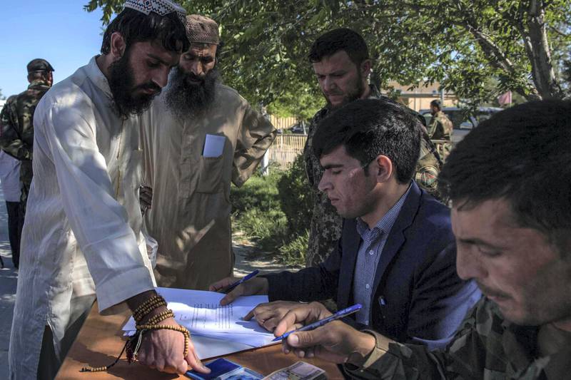 Abdullah Wasi, 27, (here, fingerprining a form) said after his release, he would do “whatever God asks of me.”Prisoners sign or fingerprint a declaration saying that they won't return to the battlefield once freed. Each one receives 5,000 Afghani ($65) for food and their journey home. Stefanie Glinski for The National