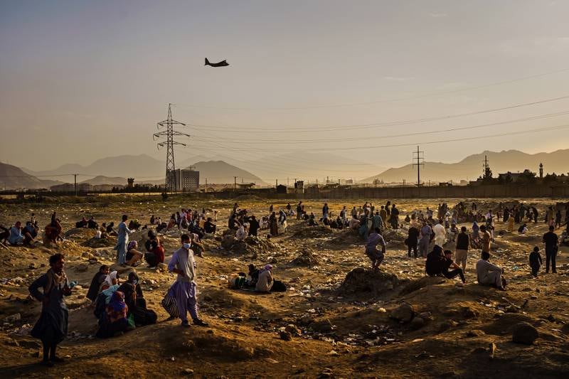 A military plane departs as Afghans hoping to leave the country wait outside Kabul airport during the fall of the city in August 2021. EPA 