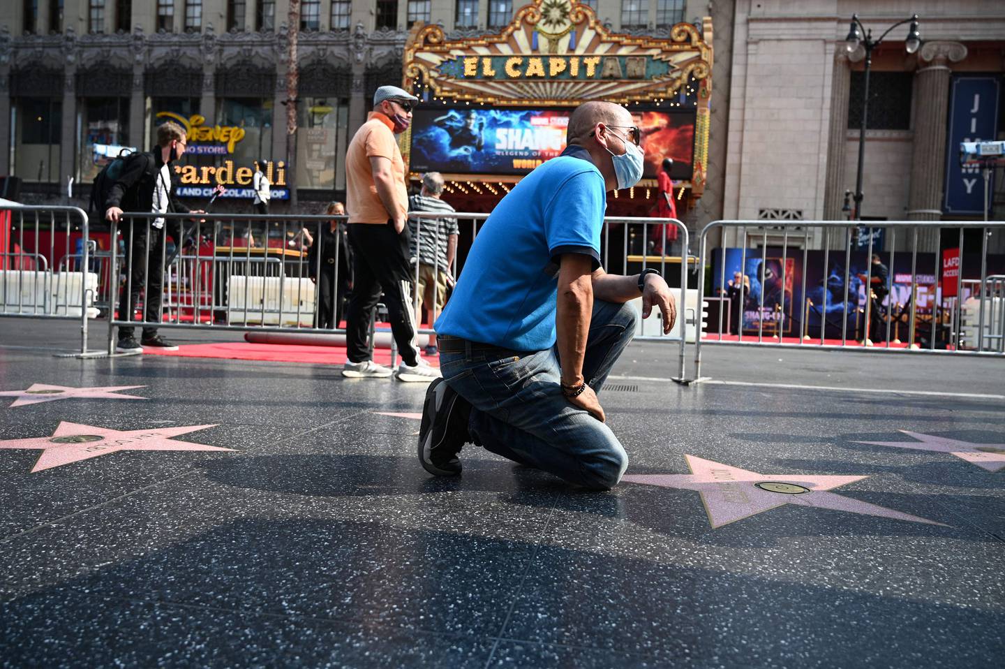 A tourist wearing a face mask poses for a snapshot next to Celine Dion’s star on the Hollywood Walk of Fame in California. AFP