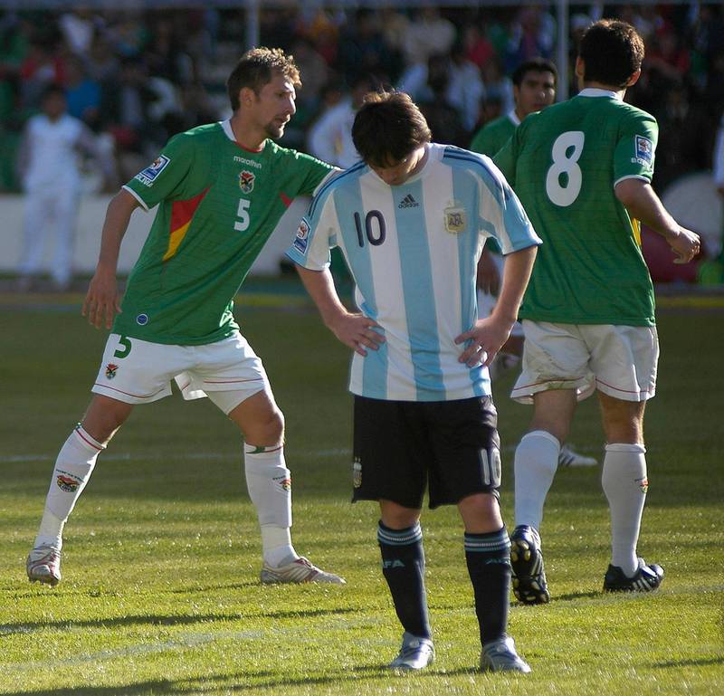 Argentina's Lionel  Messi reacts as Bolivia's Ronald Rivero (L) and Ronald Garcia (R) celebrate a goal during their 2010 World Cup qualifying soccer match in La Paz April 1, 2009.     REUTERS/Daniel Caballero (BOLIVIA SPORT SOCCER)