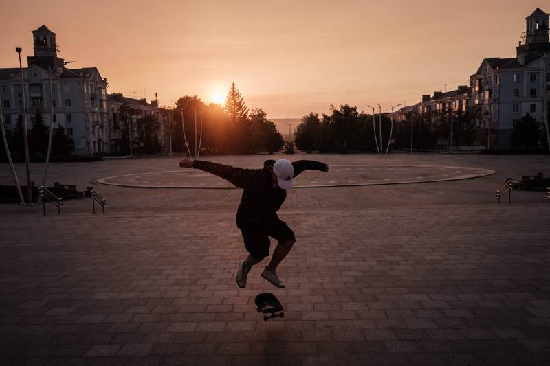 Roman Kovalenko, 18, practices the skate trick at sunset as he always skates alone since all his friends have fled at Peace Square in Kramatorsk, eastern Ukraine, on May 5, 2022, amid the Russian invasion of Ukraine.  (Photo by Yasuyoshi CHIBA  /  AFP)