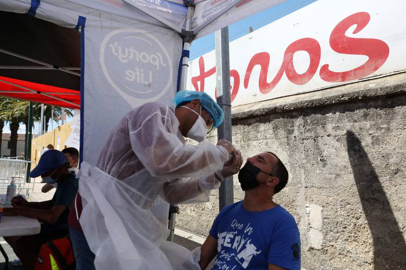 A health worker takes a nasal swab for a PCR test from a man in southern France.