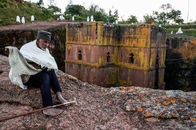 epa07922405 An elderly Ethiopian pilgrim sits in front of Saint George (or Bet Giyorgis) Church during Saint George's festival in Lalibela, Ethiopia, 04 October 2019 (issued 15 October 2019). The church of Saint George is one of eleven churches in Lalibela. The religious buildings were built at the height of medieval Ethiopian civilization from the ninth to the 12th century AD. The site of Lalibela is registered by UNESCO with the cultural inheritance of humanity since 1978. In order to protect the churches, roofs were installed above each of them except for the Church Saint Georges, which allows construction evacuation of water during heavy rains to minimize erosion.  EPA-EFE/STEPHANIE LECOCQ