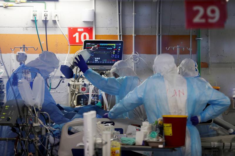 Medics, seen through a window of an observation room, wear personal protective equipment as they work inside an underground ward treating Covid-19 patients at the Critical Care Coronavirus Unit at Sheba Medical Centre in Ramat Gan.