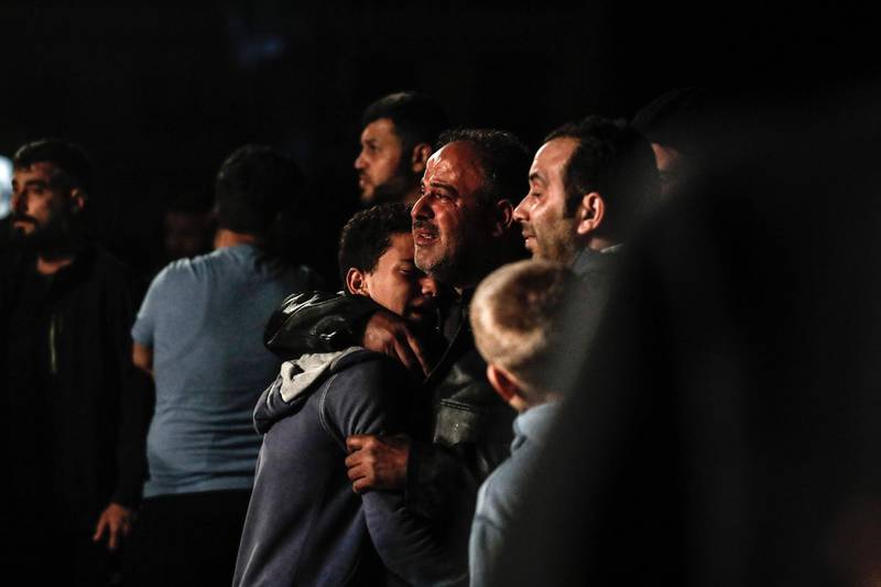 A Syrian man cries as he hugs a youngster after losing their relatives following an explosion in the rebel-held city of Idlib. Sameer Al-Doumy / AFP