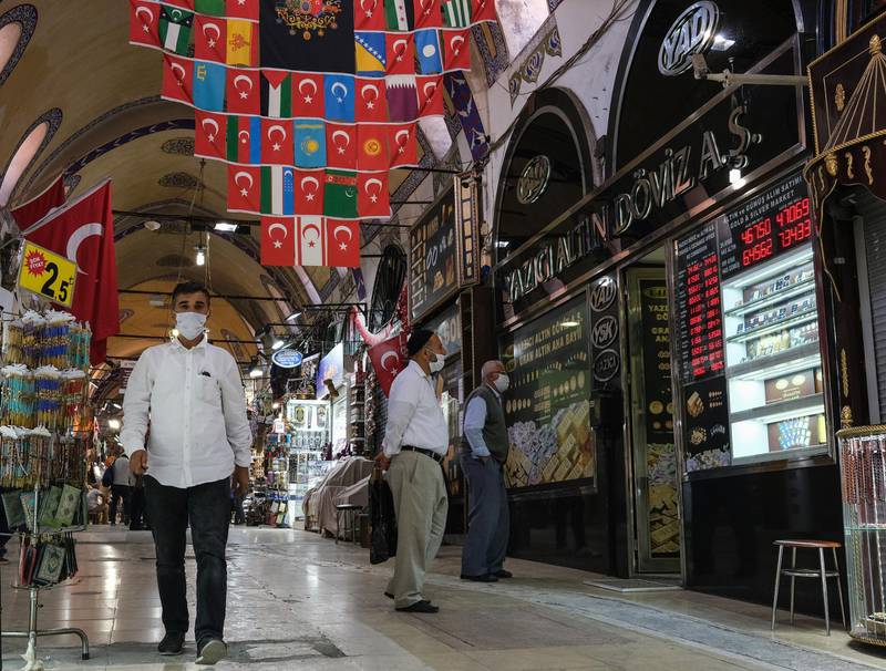 Men check rates on a board of a currency exchange office at the historical Grand Bazaar, in Istanbul, Turkey. EPA