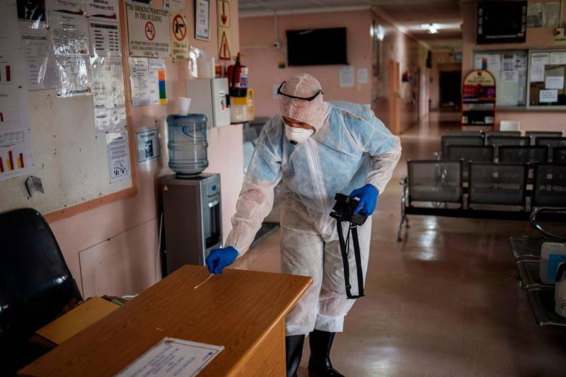 A worker performs a swab test on a desk at the Duduza Clinic that has been shut down after a nurse tested positive for the COVID-19 coronavirus in Ekurhuleni, South Africa. AFP