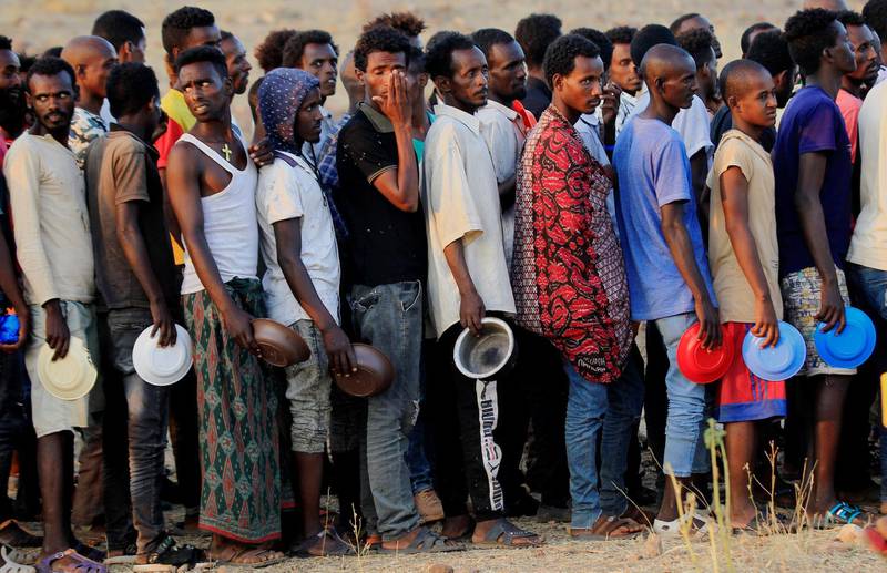 Ethiopian men who fled war in Tigray region, queue for wet food ration at the Um-Rakoba camp, on the Sudan-Ethiopia border in Al-Qadarif state, Sudan November 19, 2020. REUTERS/Mohamed Nureldin Abdallah     TPX IMAGES OF THE DAY