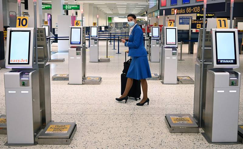 A KLM cabin crew member walks through the departures hall of Manchester Airport. AFP