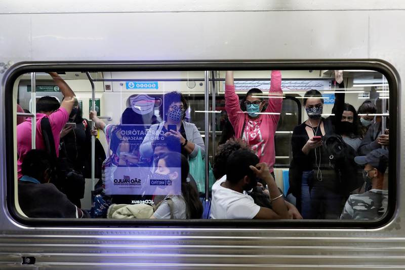 Passengers wearing protective face masks stand inside a train at a metro station in Sao Paulo, Brazil.  Reuters