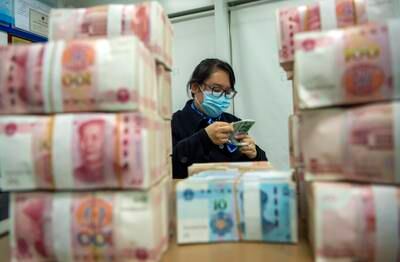 A clerk counts renminbi banknotes in Hai'an city in eastern China's Jiangsu province. AP
