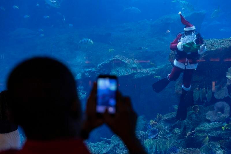 Santa Claus poses for photos in Dubai Aquarium.