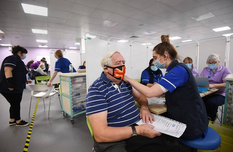 Robert Williams, 84, receives an injection of the Oxford/AstraZeneca Covid-19 vaccine at a mass vaccination centre at Epsom Downs Racecourse. AFP