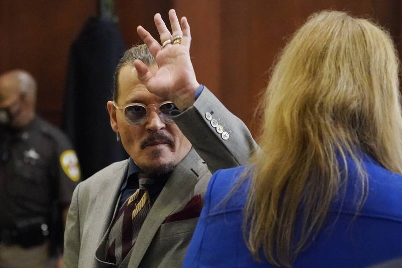 Depp waves to courtroom fans. AP