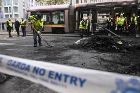 Workers clean up the debris of a burnt train behind police cordon tape on in Dublin, Ireland, on Friday. Getty Images