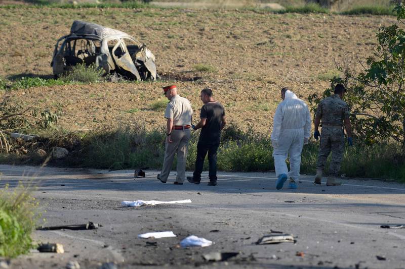 In this photo taken on October 16, 2017, police and forensic experts inspect the wreckage of investigative journalist Daphne Caruana Galizia's car after a bomb blast killed her close to her home in Bidnija, Malta.