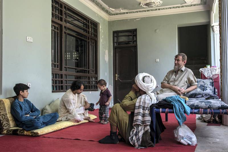 A former Soviet soldier who now goes by Nik Mohammad, 55, sits in his rental house in Kunduz surrounded by his family. 