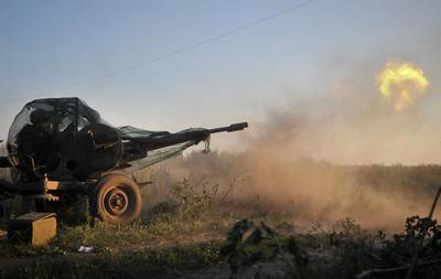 A picture made available on 24 August shows a pro-Ukrainian Donbass battalion fighter firing at pro-Russian rebels with an anti-aircraft gun in Ilovaysk, 50km from Donetsk in Ukraine.  Ivan Boberskyy/EPA