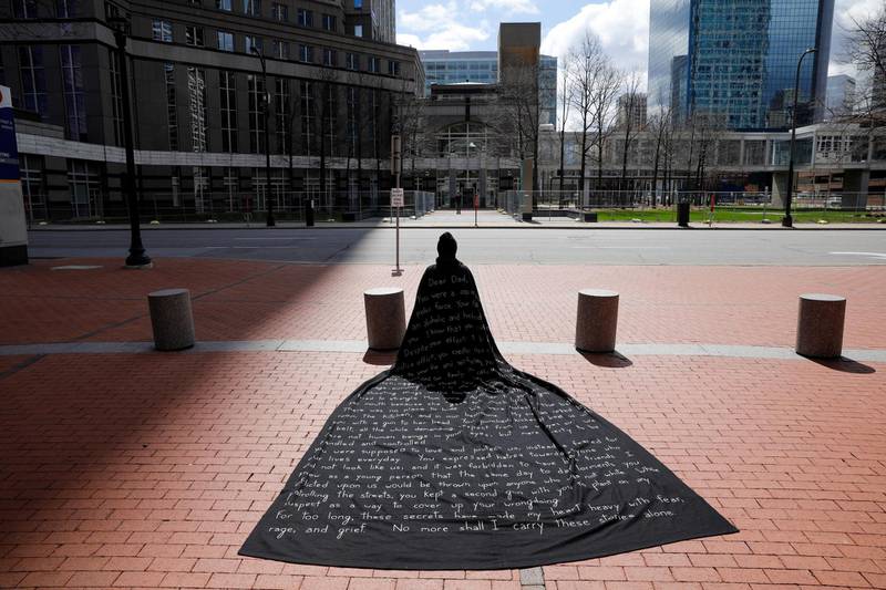 Artist Liney D wears a cape with her account of abuse at the hands of her father, a police officer, outside the Hennepin County Government Center during the trial of former police officer Derek Chauvin for the killing of George Floyd in Minneapolis, US. Reuters