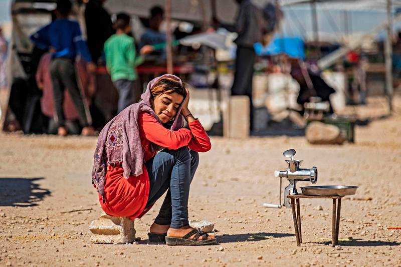A displaced Syrian girl sits next to a grinder, to grind meats or vegetables, at the Washukanni camp for the internally displaced in Syria's northeastern Hasakeh province on May 10, during the month of Ramadan. In Syria, UNICEF is transporting clean water into some of the most devastated cities and camps. Delil Souleiman / AFP
