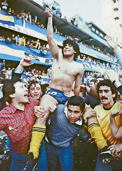 (FILE) This 1981 picture shoes Argentine soccer star Diego Armando Maradona, being carried by fans after winning the 1981 local Championship with Boca Juniors at La Bombonera stadium in Buenos Aires. Boca Juniors, the most popular football club in Argentina, celebrates on April 3rd, 2005, its centenary - from its creation by a group of football enthusiast in a humble neighbourhood of immigrants, until reaching the world's summit, and counting among its supporters with the most famous fan, Diego Armando Maradona.    AFP PHOTO/DIARIO POPULAR/NA       ARGENTINA OUT (Photo by DIARIO POPULAR / NA / AFP)