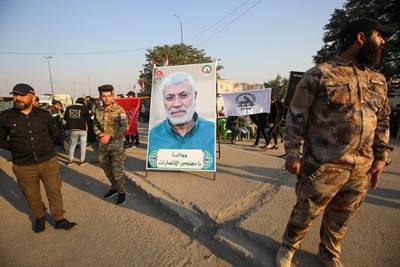Iraqi supporters of the Hashed al-Shaabi paramilitary stand next to a portrait of Iraqi commander Abu Mahdi al-Muhandis during a demonstration in Baghdad's western Shoala neighbourhood. AFP