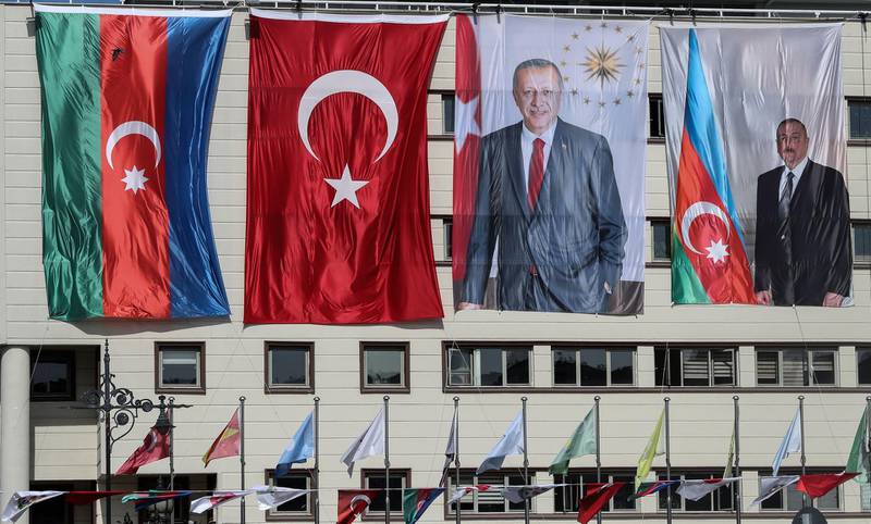 The national flags of Azerbaijan (L) and Turkey, and portraits of Turkish President Recep Tayyip Erdogan and Azerbaijani President Ilham Aliyev (R) hang side-by-side on the 
mayoral building in the Kecioren district of Ankara on October 21, 2020. 

 The origins of a flareup in fighting over Nagorno-Karabakh that has now killed hundreds and threatens to involve regional powers Turkey and Russia are hotly contested and difficult to independently verify. Both sides accuse the other of striking first on September 27 over the ethnic Armenian region of Azerbaijan. / AFP / Adem ALTAN
