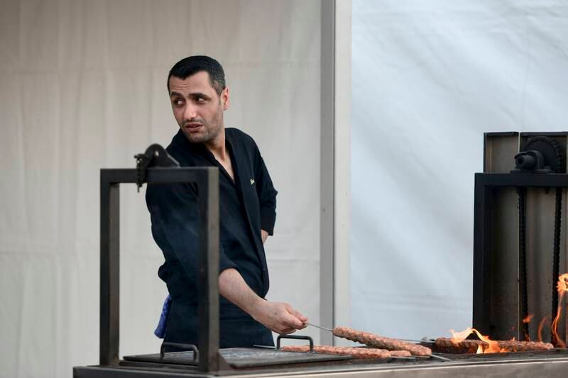 A cook from Sucre grills kebabs behind the restaurant's stall at Taste of Dubai 