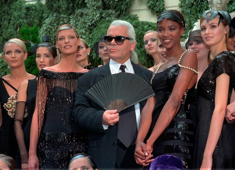 With his famous fan in hand, Lagerfeld salutes the audience along with Linda Evangelista and Naomi Campbell for Chanel's 1996-97 autumn / winter haute couture show. AP
