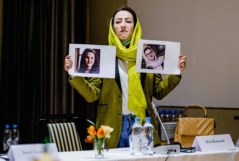 Delegate Heda Khamoush holds up photos of women’s rights activists detained in Afghanistan in Oslo, Norway. AFP