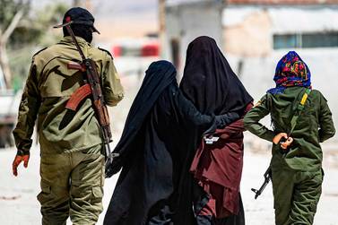 An internal security patrol escorts women, reportedly wives of ISIS fighters, in the Al Hol camp in eastern Syria. AFP