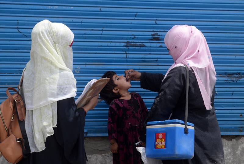 A Pakistani health worker administers polio vaccine drops to an Afghan refugee child during a polio vaccination campaign in Lahore on June 19, 2019. (Photo by ARIF ALI / AFP)