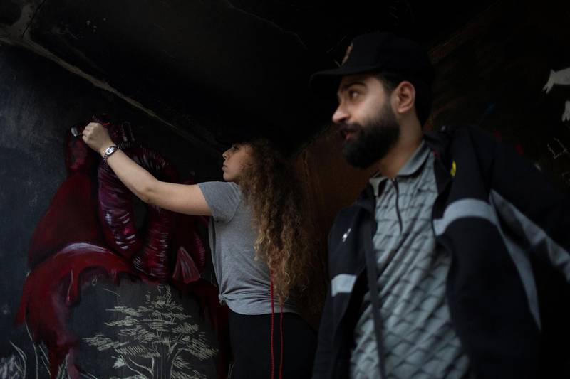 Yasmina Chahrour, (L), 17, a demonstrator, draws on a wall of the "Egg", an abandoned cinema building in Beirut, Lebanon, October 28, 2019. REUTERS/Alkis Konstantinidis     SEARCH "LEBANON EGG" FOR THIS STORY. SEARCH "WIDER IMAGE" FOR ALL STORIES