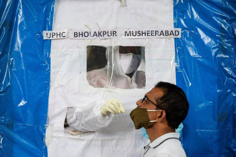 A health worker collects a swab from a resident at a makeshift free Covid-19 coronavirus testing booth in Hyderabad, India. AFP