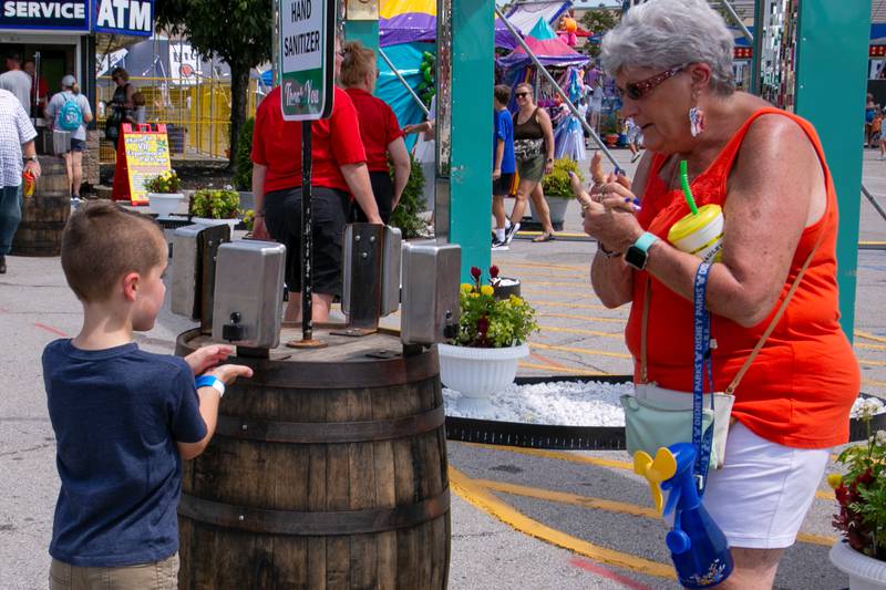 A woman instructs her grandson to clean his hands at the State Fair in Louisville, Kentucky. Reuters