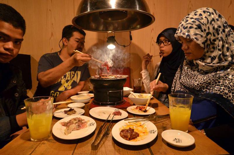 Thai Muslim tourists enjoying Halal certified foods at a barbecue restaurant in Tokyo.  Prayer rooms, hijabs made from local silk and even Halal-certified whale meat are appearing in Japan as tourism bosses wake up to the demand from Muslim travellers. AFP PHOTO / Yoshikazu TSUNO

