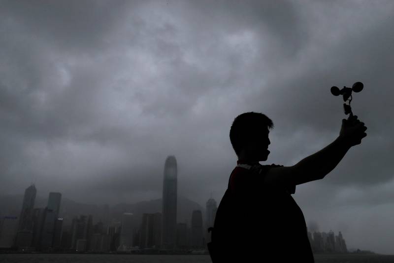 A man raises an anemometer against the strong wind caused by tropical storm Pakhar on the waterfront of Victoria Habour in Hong Kong. Vincent Yu / AP Photo