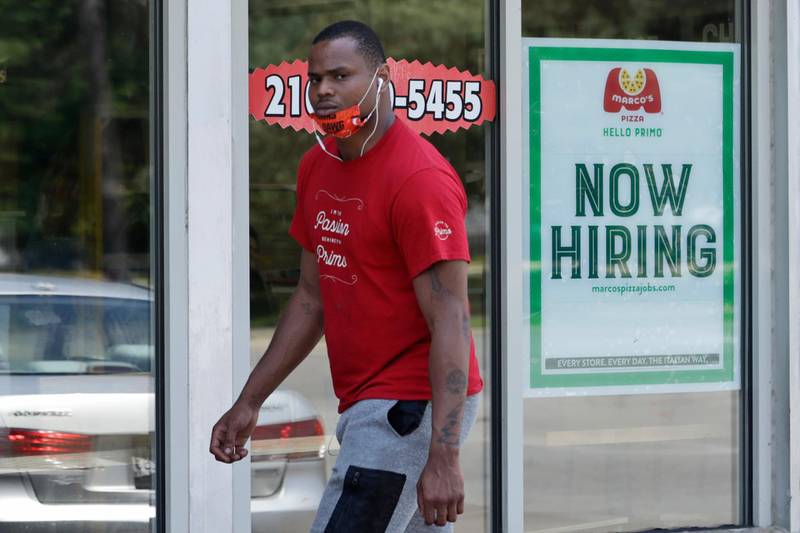 A man walks past Marco's Pizza, which is now hiring, Friday, June 5, 2020, in Euclid, Ohio. U.S. unemployment dropped unexpectedly in May to 13.3% as reopened businesses began recalling millions of workers faster than economists had predicted, triggering a rally Friday on Wall Street. (AP Photo/Tony Dejak)