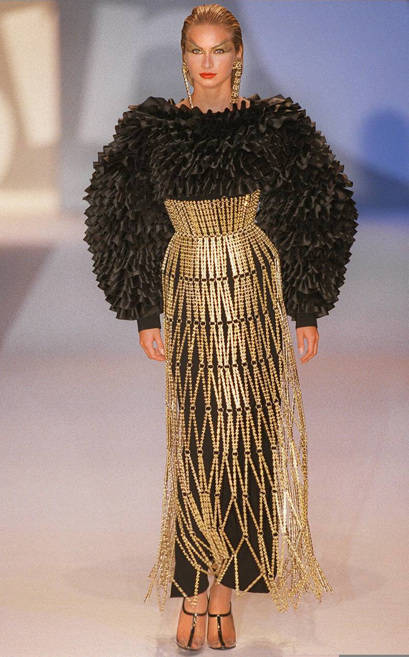 A model presents a ruffled black top over a straight black and gold link dress during Rabanne's autumn/winter 1997 high-fashion collection in Paris. AFP