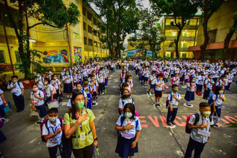Pupils at Pedro Guevarra Elementary School in Manila attend a flag-raising ceremony on August 22, the first day of in-person classes, following two years of Covid-19 lockdowns in the Philippines. AFP