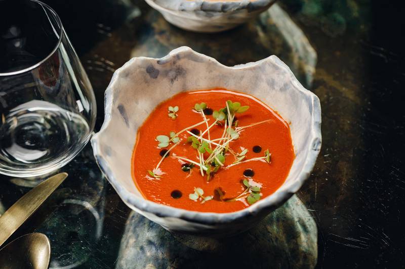 Vine tomato soup with aji rocoto, herb oil and goat's cheese at Coya 