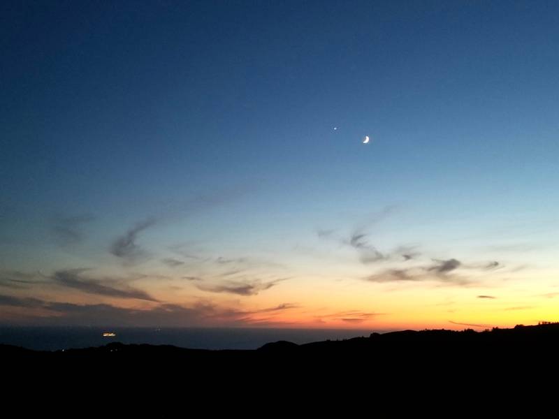 The crescent Moon passing by Venus during sunset. Photo: John Ferry