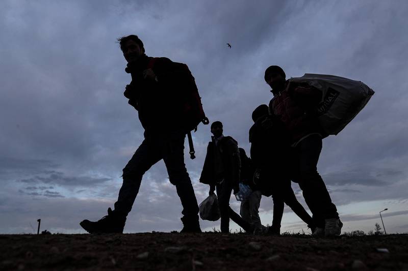 epa08269764 A group of migrants and refugees walk to Pazarkule Border gate during the sunset at the city center of Edirne, Turkey, 04 March 2020. Thousands of refugees and migrants are gathering on the Turkish side of the border with Greece with the intention of crossing into the European Union following the Turkish government's decision to loosen controls on migrant flows after the death of 33 Turkish soldiers killed in an attack in Idlib, Syria, on 27 February 2020.  EPA/SEDAT SUNA