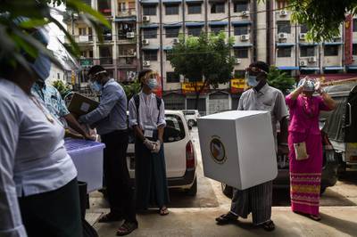 Election staff carry a mobile ballot box in Yangon last week, as advance voting in the country's election began for elderly people. AFP