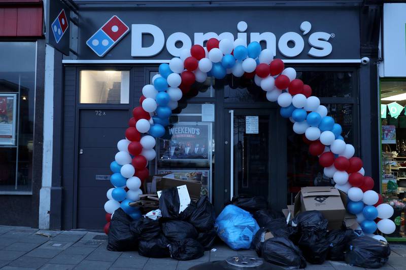 FILE PHOTO: Balloons and rubbish are seen at the shop front of a newly opened Domino's Pizza franchise in London, Britain, early morning March 14, 2017.    REUTERS/Russell Boyce/File Photo