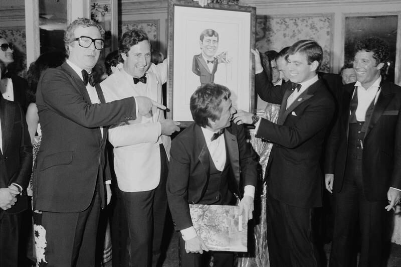 Actors Michael Caine, Dudley Moore, singer Tom Jones and Prince Andrew, who is holding a cartoon of himself, attend a gala dinner to honour the prince by the British Olympic Association at the Beverly Wilshire Hotel in Beverly Hills, California, in 1984.