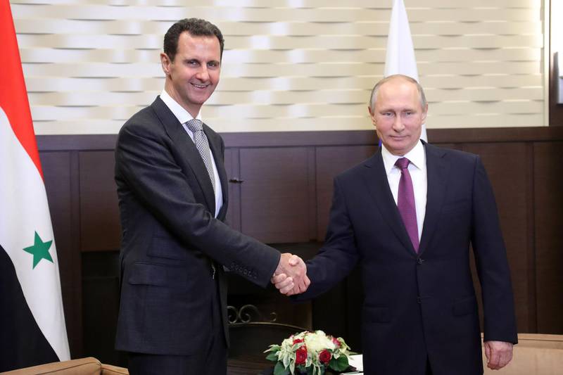 TOPSHOT - Russia's President Vladimir Putin (R) shakes hands with his Syrian counterpart Bashar al-Assad during a meeting in Sochi on November 20, 2017. / AFP PHOTO / SPUTNIK / Mikhail KLIMENTYEV